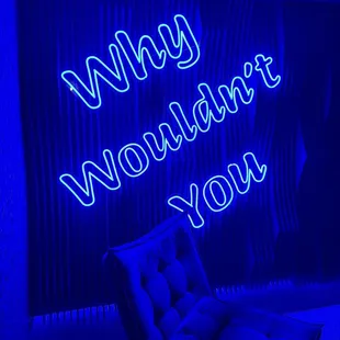 a chair in front of a neon sign