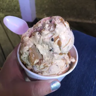 a hand holding a cup of ice cream