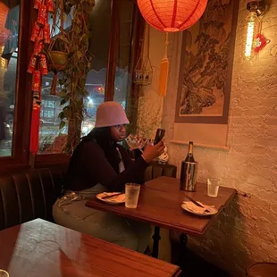 a woman sitting at a table in a restaurant