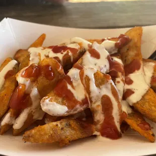 Fries in white sauce with some spicy red