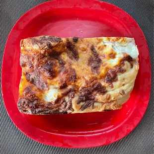 a slice of pizza on a red plate