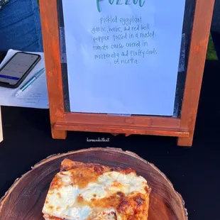 a slice of pizza on a wooden board