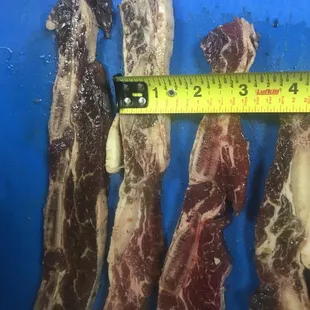 a ruler measuring the length of a piece of meat