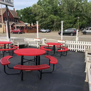 red picnic tables and a white picket fence