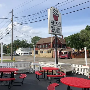 red picnic tables and a white fence