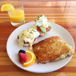 Eggs Benedict on a biscuit with tomato, avocado and hollandaise. Side of perfectly crispy hash browns