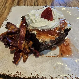 French Toast Cassarole, topped with strawberry compote and cream cheese icing. Side of beef bacon.