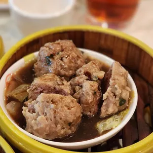a bowl of soup with meatballs
