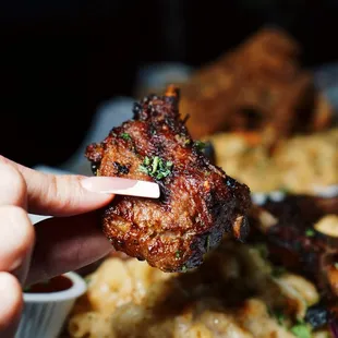 a hand holding a piece of meat