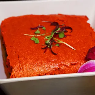 a square piece of food in a dish