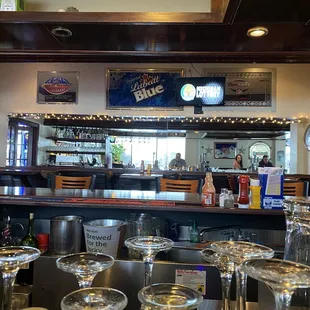 rows of empty wine glasses on the bar