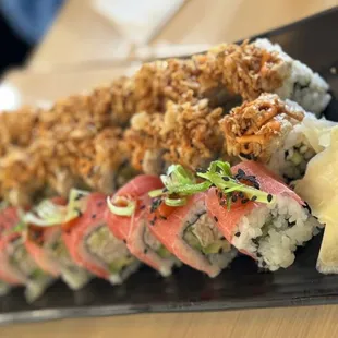 a variety of sushi on a black plate