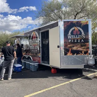 a group of people standing around a food truck