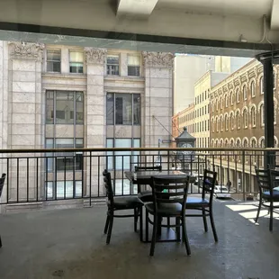 a balcony with tables and chairs