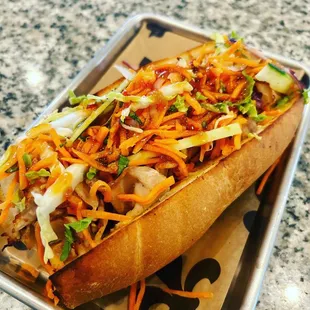 a hot dog with coleslaw and carrots
