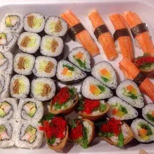 a tray of sushi and rolls