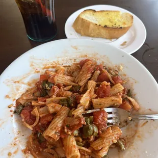 Partially eaten pasta with olives, capers, stewed tomatoes, lots of garlic.