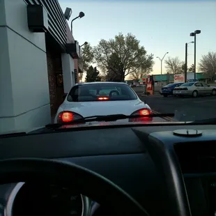 a white car driving down a street