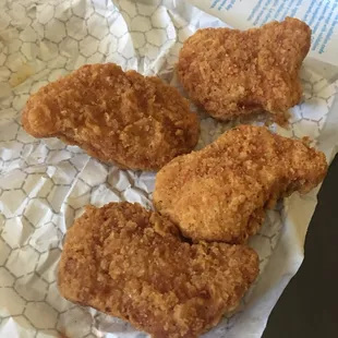 three pieces of fried chicken on a wrapper