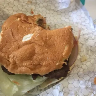 a half eaten hamburger with a bite taken out of it