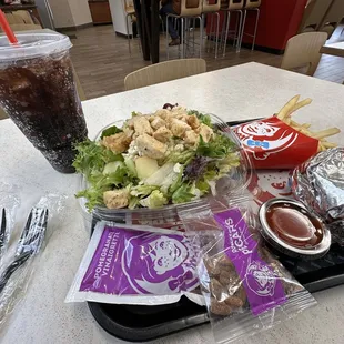 a salad and a drink on a tray