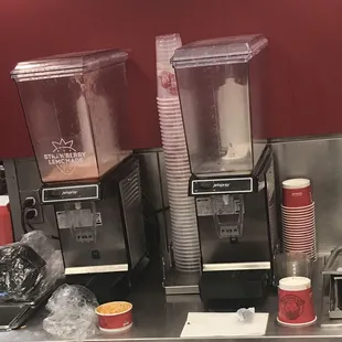 two blenders and cups on a counter