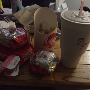 a cup of coffee, a bag of chips, and a drink on a table
