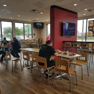 people sitting at tables in a fast food restaurant