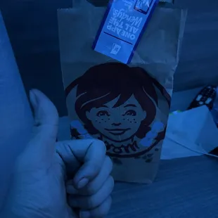 a hand holding a paper bag