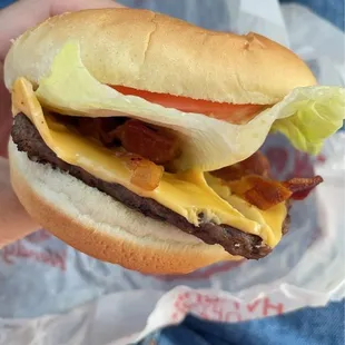 a hand holding a cheeseburger