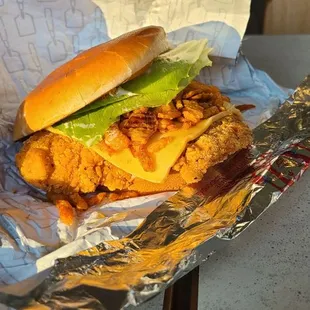 a chicken sandwich with lettuce and cheese