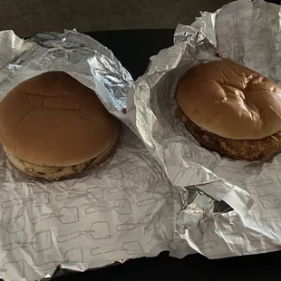 two hamburgers wrapped in tin foil