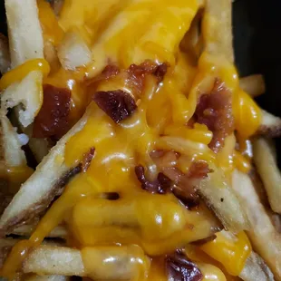a plate of fries with cheese and bacon
