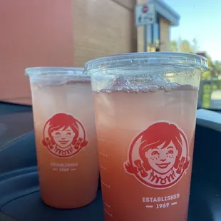 two drinks in plastic cups on a tray