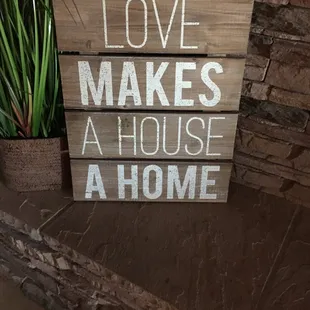 a wooden sign that says love makes a house at home