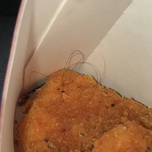 a piece of fried chicken in a paper container