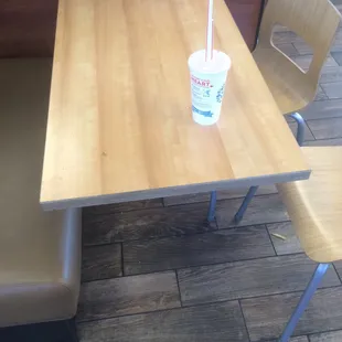 a table with a drink and two chairs