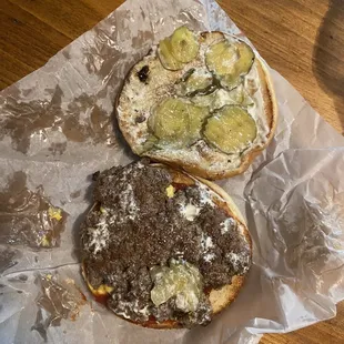 two burgers on a piece of wax paper