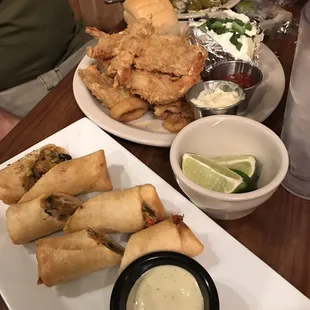 a plate of fried spring rolls and a bowl of dipping sauce