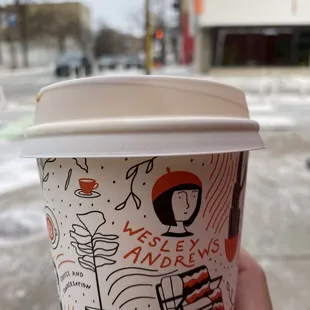 a hand holding a cup of coffee