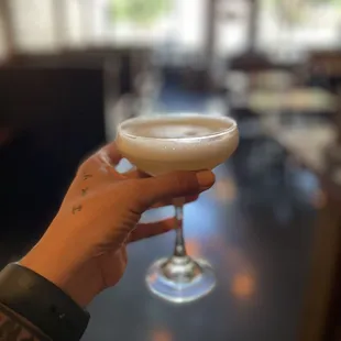 a person holding a glass of beer