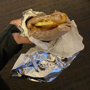 a person holding a sandwich
