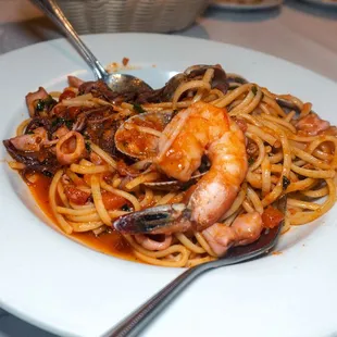 a plate of pasta with shrimp and clams