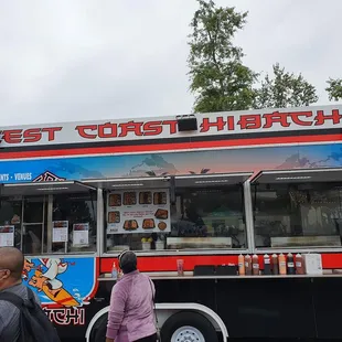 a man and a woman standing in front of a food truck