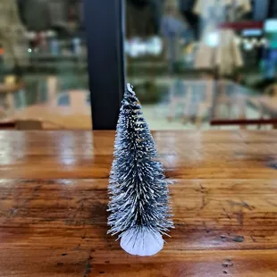 Little snow flocked Christmas tree table decorations as of 11/29/23