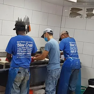 three workers in a kitchen