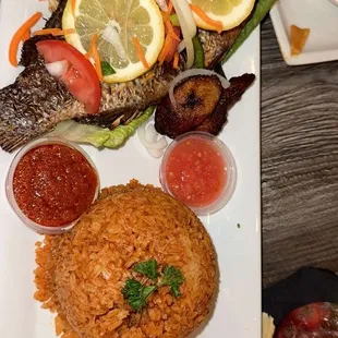 Jollof rice with baked tilapia fish. The West Hut with fish.  The West Hut