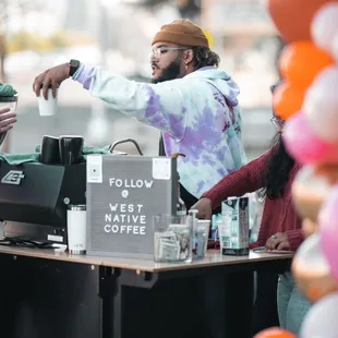 a man handing a cup of coffee to a customer