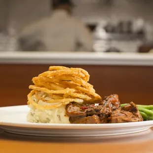 Grilled marinated BBQ Tenderloin Steak Tips topped with crispy hand cut onion strings