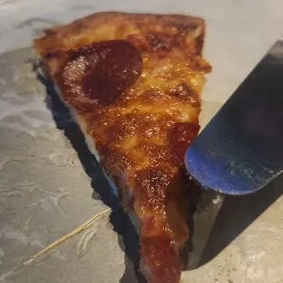 a slice of pizza on a plate with a knife